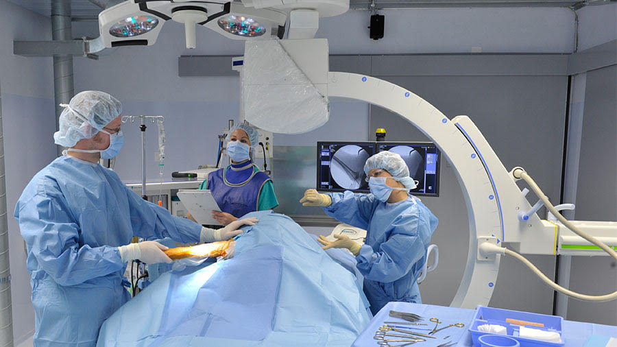 Surgeons performing procedure with C-arm imaging